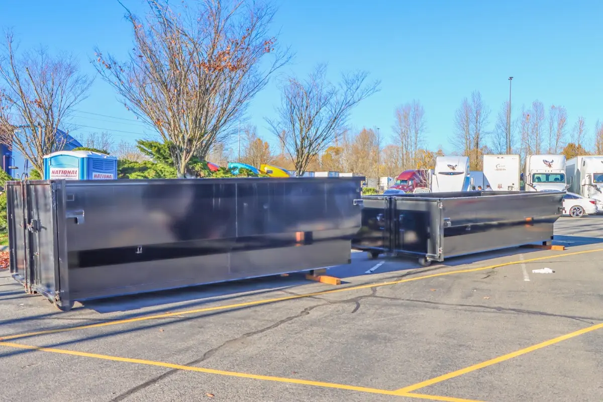 Professional dumpster rental service with roll-off container on residential driveway in Forest Hills